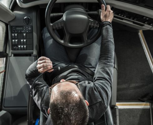 A coach bus driver behind the wheel